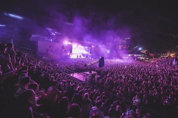 A large group of people in a stadium at an evening music concert. Original public domain image from Wikimedia Commons